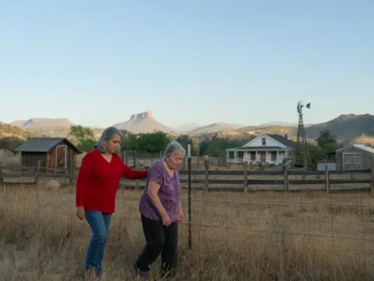 Senior caregiver walking with a client living with dementia on a property near Willcox, Arizona