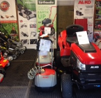 red ride on lawnmower along with other lawnmowers.