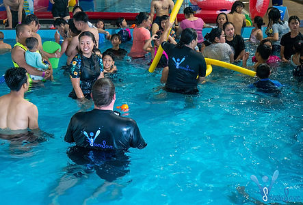 Happy students, children and parents learning to swim and water safety
