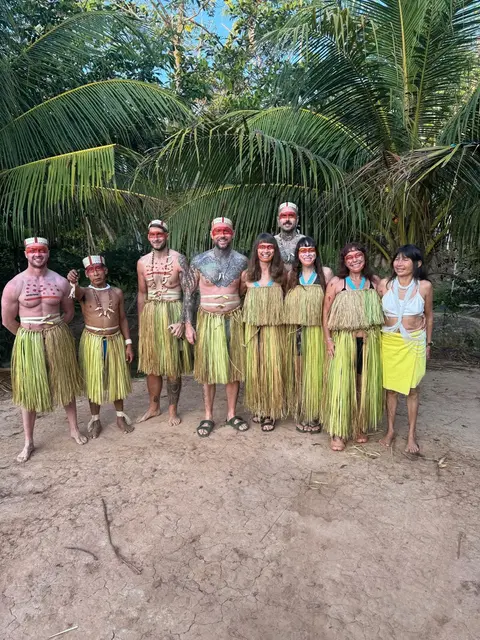 Group of locals, smiling in traditional clothing, standing together, posing outdoors