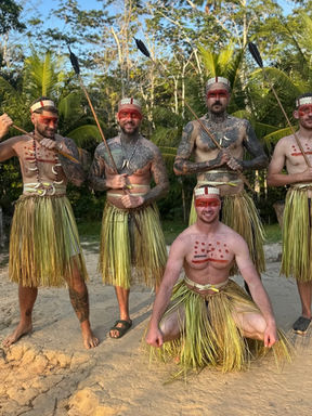 Group of indigenous men hold spears, stand on sand ground, Lewis Powell