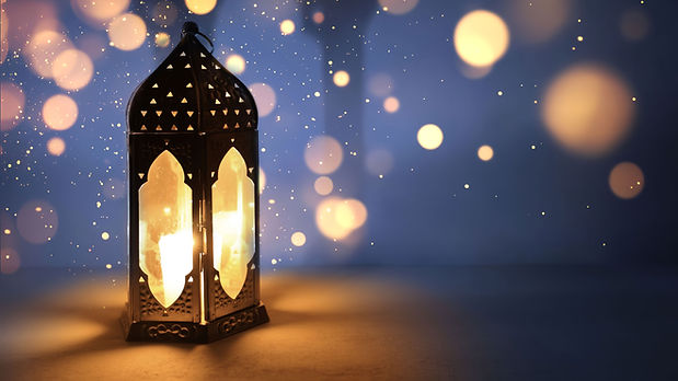 Ornamental dark Moroccan, Arabic lantern on table burning at night Glittering bokeh lights