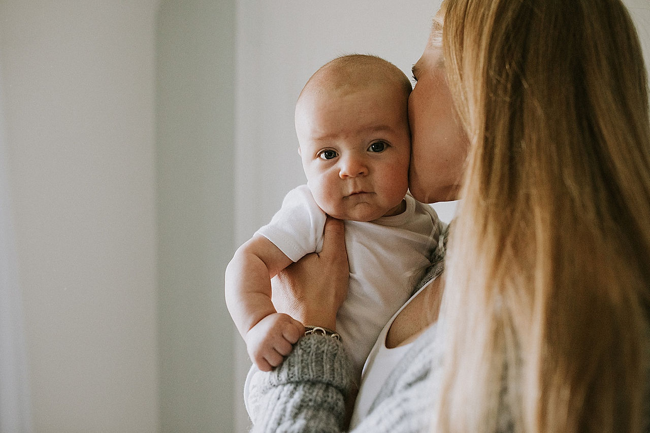 Mother kissing baby boy on the cheek
