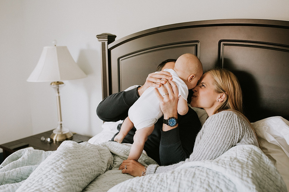 Mom kissing baby in bed