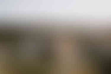 Groom opening giant bottle of champagne at wedding