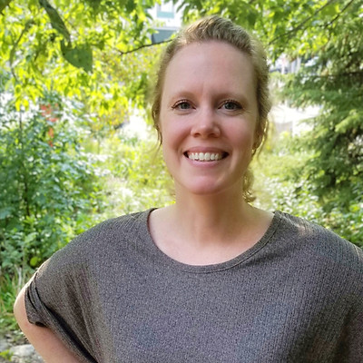 Photo of Professional Organizer, Veronica Johnson smiling with her hands on her hips in a wooded scene