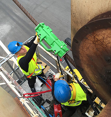Close-up of steel wire rope showing lubrication process to reduce corrosion and wear in heavy-duty lifting applications