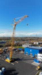 Sarens SCC2000A-EV fully electric crawler crane performing a heavy lift on a construction site.