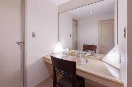 ホテルの客室にある鏡と椅子のある洗面化粧台