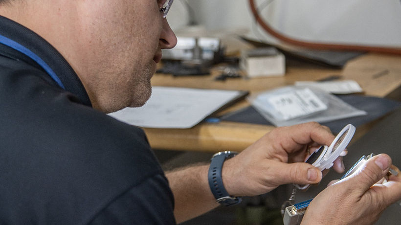 M6 Revolutions engineer inspecting a connector at the bench