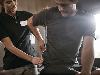 a physical therapist helping a man with lower back pain