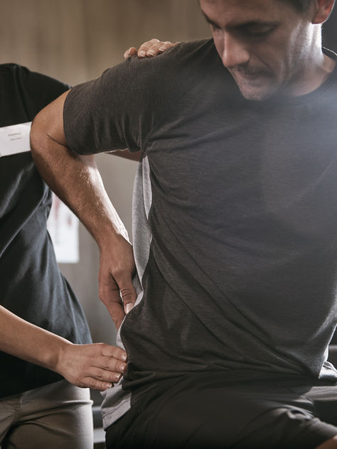 Physiotherapist assessing a runner experiencing lower back pain