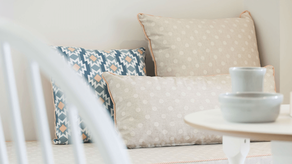 דירה - תל אביב: כריות דקורטיביות בגוונים בהירים על ספה