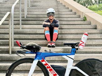 Female endurance athlete recovering after training with a triathlon bike.