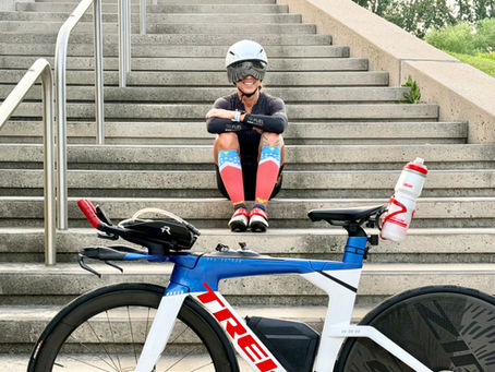 Female endurance athlete recovering after training with a triathlon bike.