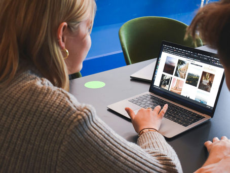 Two professionals collaborating on a laptop, reviewing a website to build B2B trust