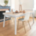 Table extensible ÉGÉE en chêne massif et laque blanche - vue en ambiance dans une salle manger contemporaine lumineuse