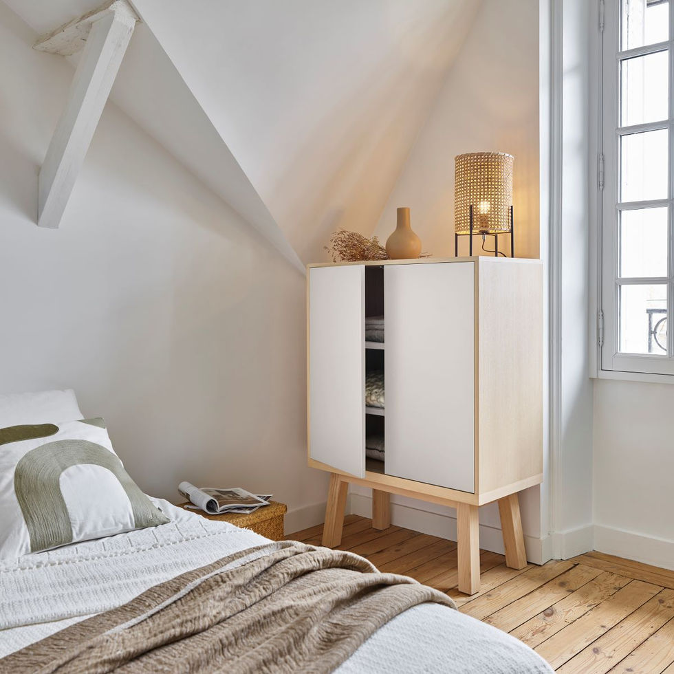 French design 2-door white low wardrobe in wood in a room placed between a bed and a window