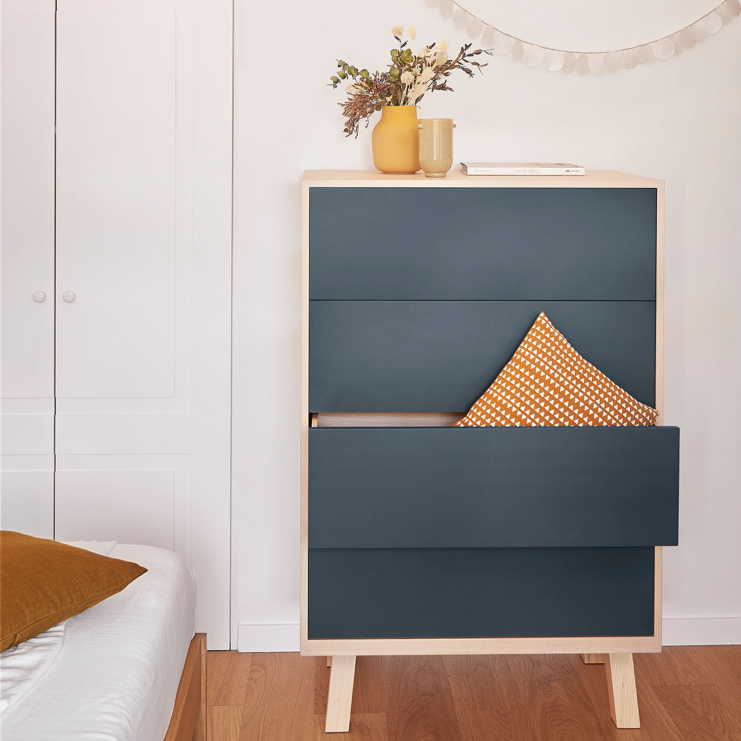 french design low and medium large wooden 4-drawer dark blue chiffonier in a bedroom