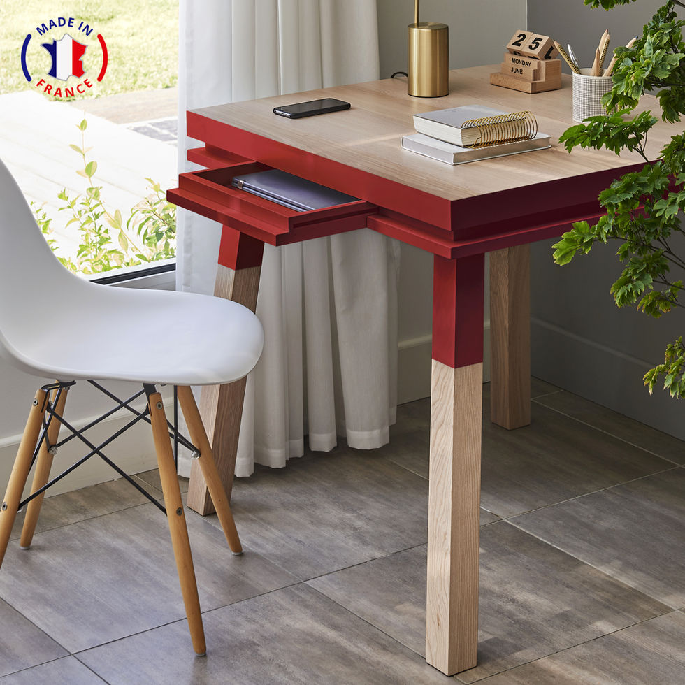 red design square desk with an opened drawer and a chair in front of a window