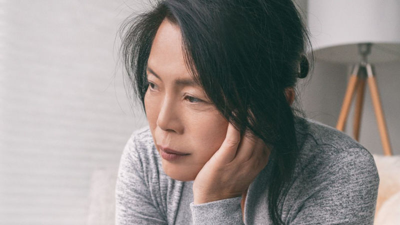 Woman looking to the left of frame looking sad