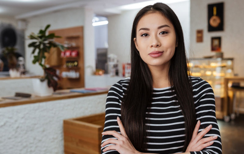 Confident person smiling slightly at the camera wearing a stripey top