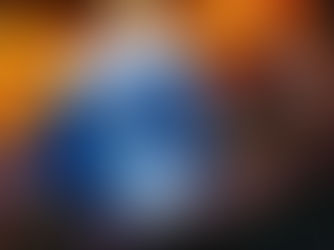 A person holds a blue and white Disney Starlight popcorn bucket with Elsa design. Warm lights glow in the blurred background, creating a festive mood.