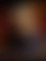 Stack of sugar-coated cookies on dark ceramic plates, autumn leaves in background, creating a warm, rustic atmosphere.