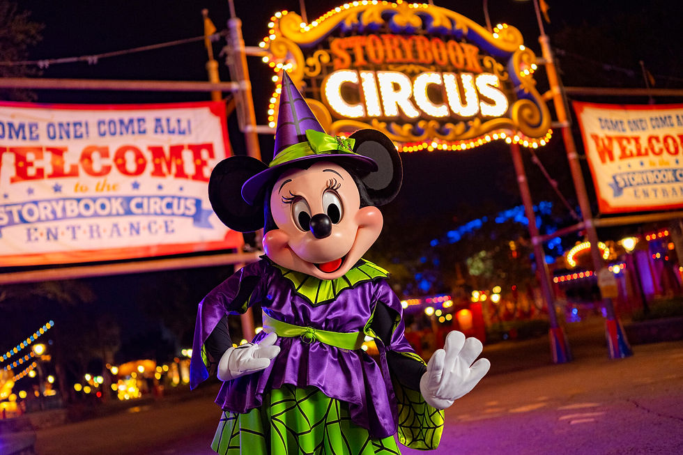 Character in a purple and green costume stands in front of "Storybook Circus" sign at night, with colorful lights and welcoming banners.