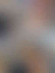 Close-up of a blue Stitch-themed headband held in a store. Background shows mannequins in summer clothes, a surfboard, and colorful accessories.