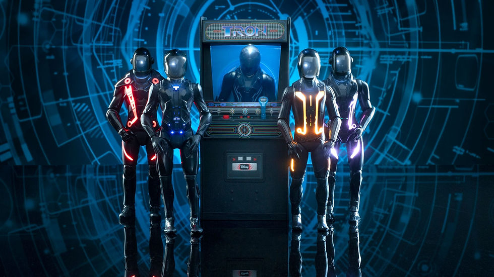 Sci-fi scene with four people in glowing suits beside a "Tron" arcade machine. Blue digital-themed background enhances futuristic vibe.
