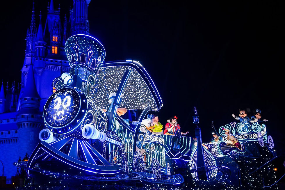 Illuminated parade float with cartoon characters, adorned in blue lights. Castle backdrop at night. Bright and festive mood.