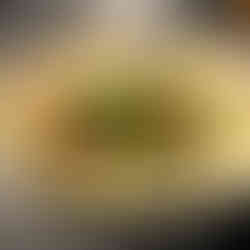 Risotto covered in baby tomatoes and herbs in a white bowl