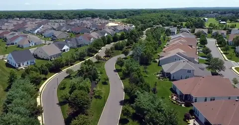 Aerial view of a suburban neighborhood with winding roads and numerous houses. | Down To Earth Landscaping | Jackson New Jersey, USA (732) 833-7702