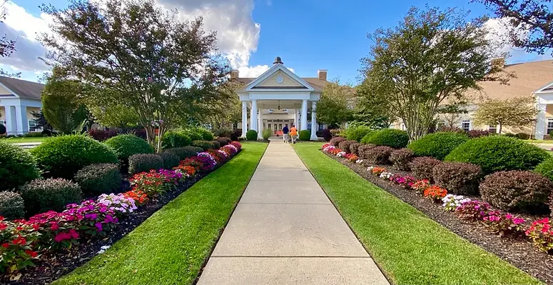 Grand building entrance with a paved path and colorful flowerbeds. | Down To Earth Landscaping | Jackson New Jersey, USA (732) 833-7702