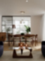Stylish dining room with a wooden table, glass chandelier, green plants, and large windows. Warm ambiance with lit candles on a glass table.