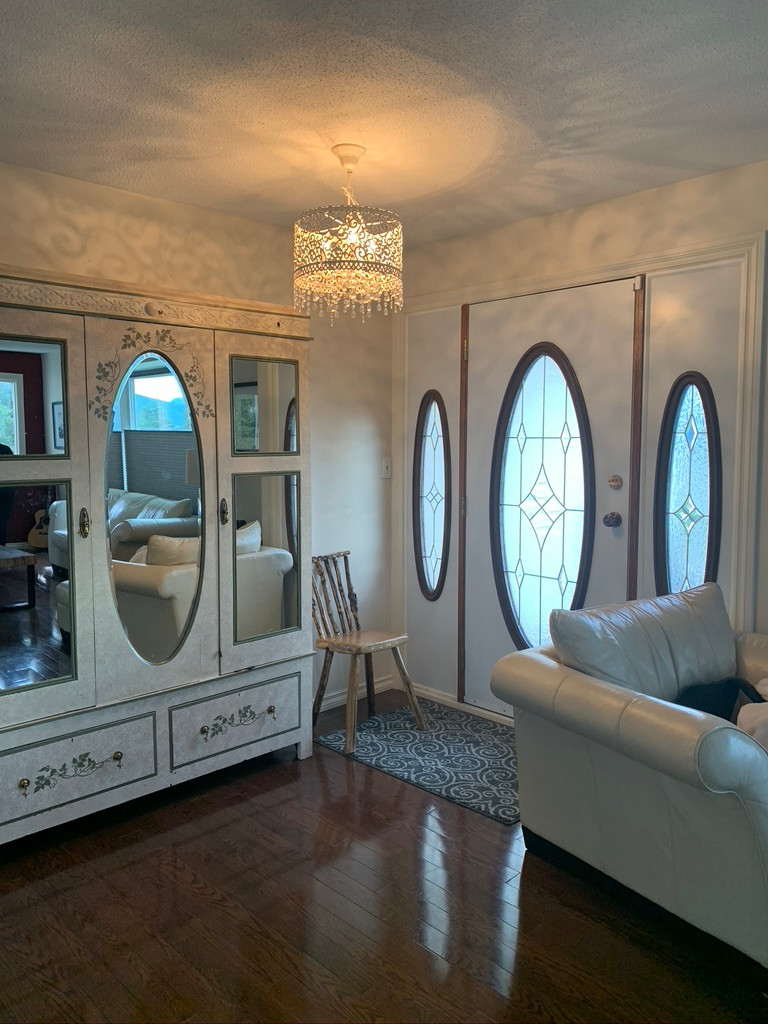 Entry Way with Oversized White Armoire and Ornate Chandelier