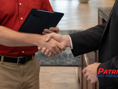 Local pest control representative shaking hands with property manager in commercial office lobby