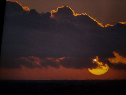 orange sunset behind dark clouds