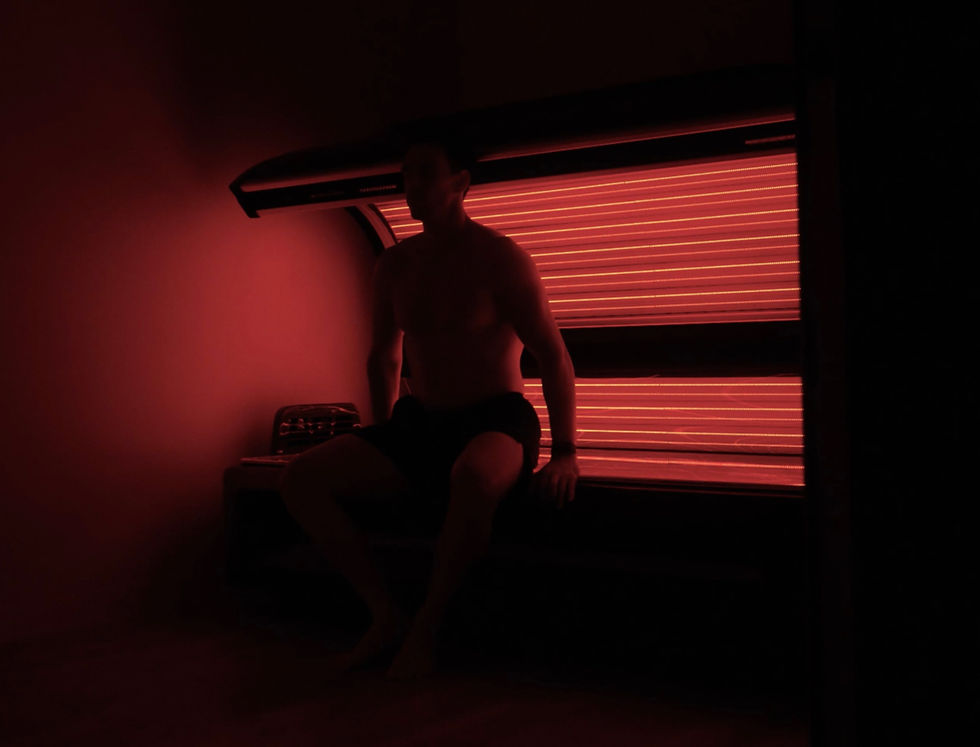 man sitting on a red light therapy pod