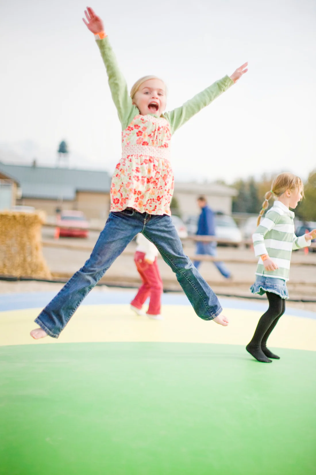 A girl having fun jumping on a jumping pillow.