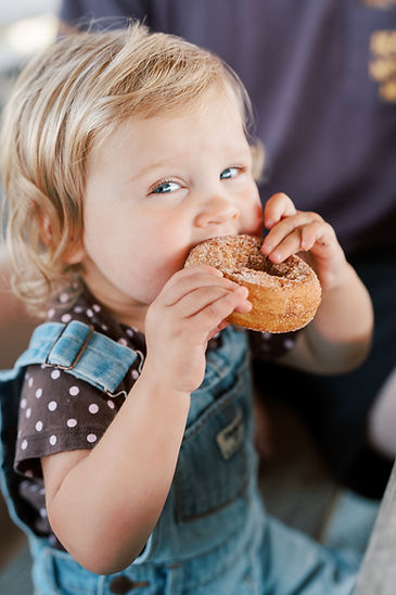 A young boy eating a donut.