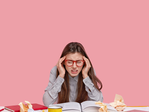 Teenage girl overwhelmed by exam revision books