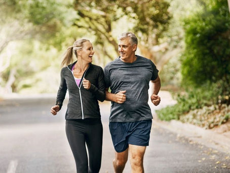 healthy middle aged man and woman running happy at park