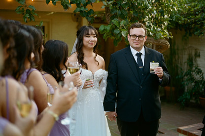Bride and Groom cheers with bridal party shot on film.