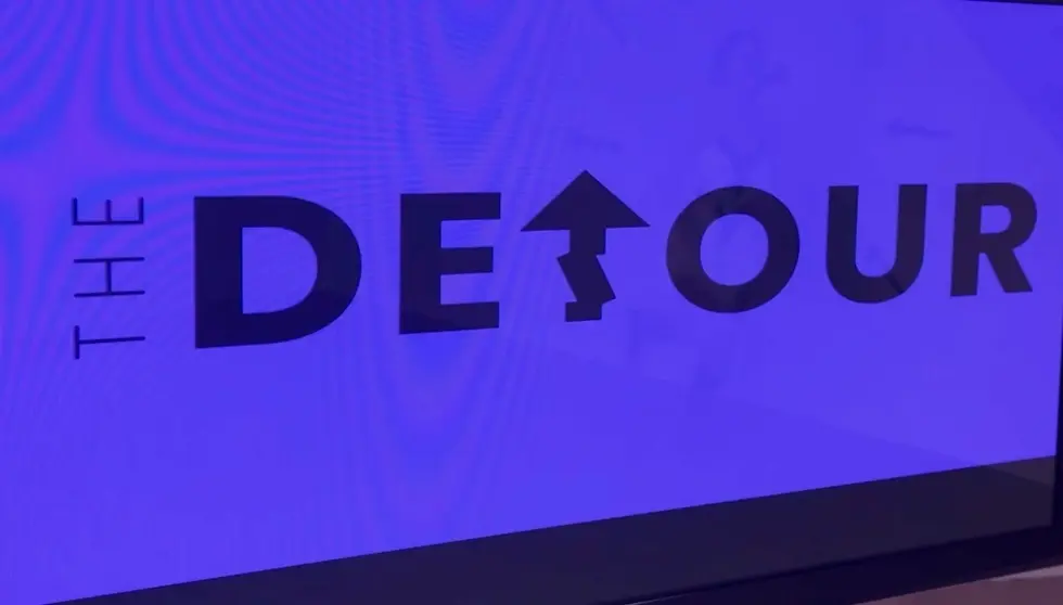 Flatscreen tv displays signage that reads "The Detour" in the basement of a Pittsburgh Choreography studio.