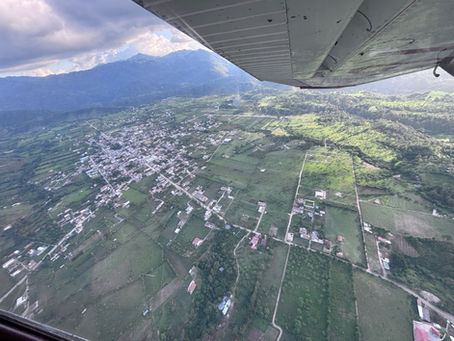 A view of Guatemala from the air with the wring of an airplane in view