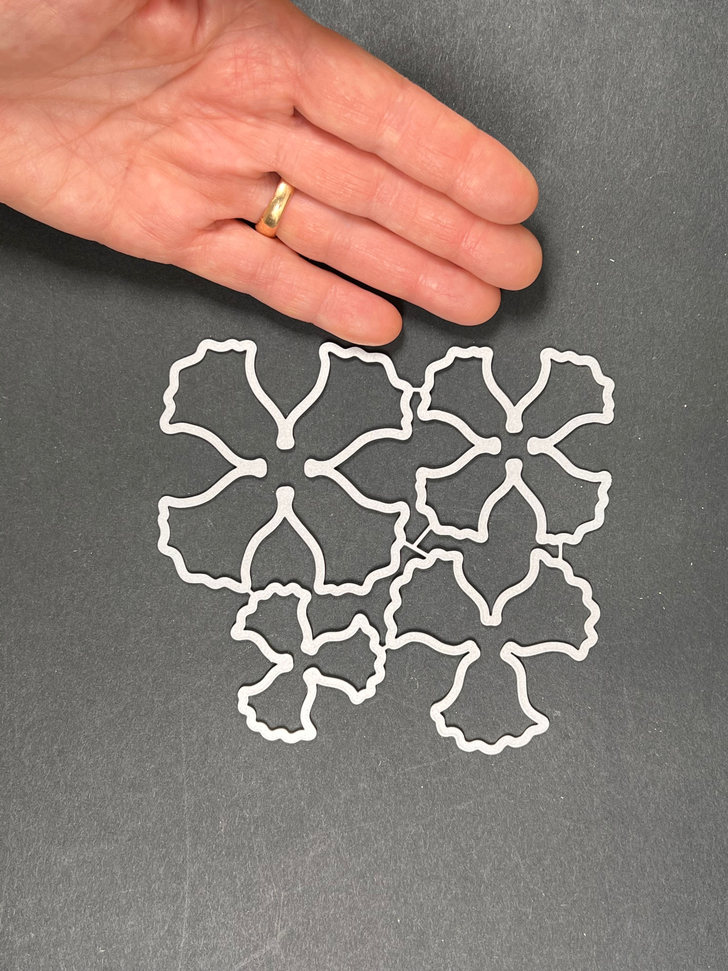 Thin steel flower die cuts for shrink plastic bead molds.