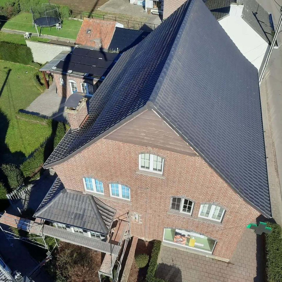 Professionele renovatie van een hellend dak met grijze dakpannen en naadloze aansluiting van dakkapellen door Dakwerken Honinckx Soogelée