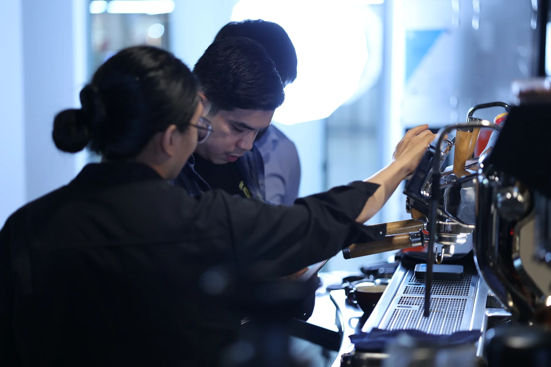 Hands-on espresso instruction with students at the coffee bar.